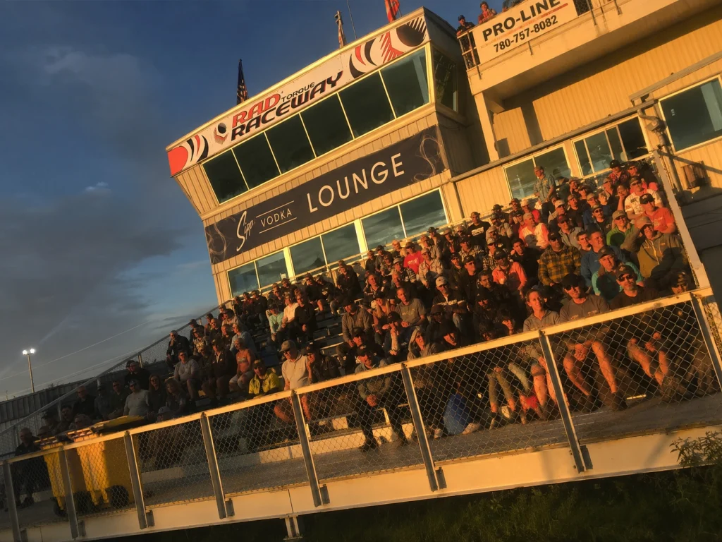 An image of motorsports fans at RAD Torque Raceway in the VIP Octane Club seating area just below the drag tower.